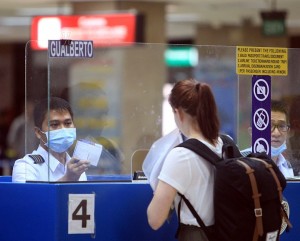 MERS CO/JUNE 11,2015: Immegration personnel at Mactan Cebu International Airport wears protective mask following the reported Mers-Cov virus in South Korea. (CDN PHOTO/TONEE DESPOJO)